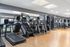 Modern gym facility featuring state-of-the-art treadmills, elliptical machines, and strength training equipment in a bright, spacious setting.