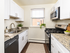 Modern kitchen boasting sleek white cabinetry, stainless steel appliances, and a granite countertop, offering a bright and inviting culinary space.