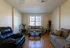 Inviting living room with plush sofas, elegant glass coffee table, and warm wooden flooring; ideal for relaxation and gatherings.