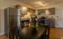 Contemporary kitchen with sleek gray cabinets, stainless steel appliances, and elegant dining set in a well-lit space.