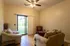 Cozy living room with plush seating, natural wood flooring, and abundant sunlight streaming through sliding glass doors to a lush garden.