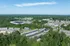 Scenic aerial view of modern residential apartments surrounded by lush greenery and expansive landscapes, offering a perfect blend of tranquility and urban convenience.