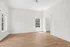 Bright and inviting empty room featuring beautiful hardwood floors, large windows allowing natural light, and a spacious walk-in closet entrance.