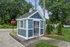 Charming blue and white security shack amidst lush green surroundings, showcasing a welcoming community entrance.