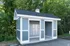 Charming community mail center with blue siding and a traditional peaked roof, nestled in lush greenery.