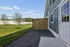 Charming apartment exterior with a spacious backyard, lush green grass, and a sleek privacy fence for serene outdoor enjoyment.
