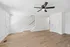 Bright and inviting interior showcasing elegant hardwood floors, modern ceiling fan, and a cozy stairway leading to upper floors.