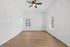 Bright, airy room with elegant wood flooring, large windows, and modern ceiling fan, perfect for bedroom or office space.