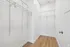 Spacious walk-in closet with sleek shelving and elegant wood floor, offering ample storage and modern design.