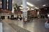 Spacious and elegant atrium with polished flooring, lush plants, and comfortable seating under a high ceiling and soft lighting.