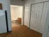 Bright apartment hallway with elegant wood flooring leading to a pristine bathroom and spacious closets.