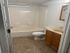 Bright and pristine bathroom featuring a full bathtub, sleek vanity, and modern tile flooring.