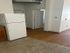 Modern apartment interior featuring a sleek kitchen area transitioning into a hallway with elegant wood flooring.