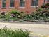 Charming brick building exterior with vibrant flower garden, showcasing historic architectural style and colorful landscaping.