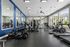 Modern fitness center with large mirrors, state-of-the-art exercise equipment, and abundant natural light.