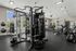 Modern fitness center with state-of-the-art equipment, large windows for natural light, and a welcoming environment for an active lifestyle.