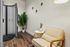 Modern tanning booth, elegant chair, and leafy plant for a serene retreat.