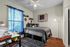 Charming bedroom with stylish decor, featuring a cozy bed, vibrant blue curtains, and a chic workspace.