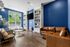 Chic clubhouse with stylish blue walls, modern seating, and elegant built-in shelves, offering a cozy yet sophisticated ambiance.