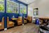 Charming Study nooks with plush leather booths and vibrant blue walls, complemented by large windows showcasing lush greenery.