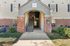 Inviting apartment entrance with elegant brick facade, offering easy access to multiple floors via a central staircase.