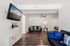 Contemporary living room with sleek hardwood floors, cozy seating, and mounted flat-screen TV, perfect for relaxation.