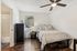 Inviting bedroom with cozy bed, stylish decor, and natural light from a large window, offering a serene retreat.