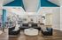 Spacious and modern lounge area with sleek seating, stylish decor, and abundant natural light, ideal for relaxation and entertainment.