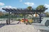 Inviting outdoor patio with modern pergola, vibrant seating, and lush surroundings, perfect for relaxation and social gatherings.