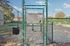 Inviting community dog park with charming entrance and spacious play area, featuring vibrant natural surroundings and clear safety guidelines.