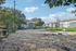 Inviting outdoor community space with a spacious sandy play area, surrounded by lush greenery and apartment buildings, perfect for recreation and relaxation.