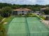 Vibrant apartment community featuring a well-maintained tennis court and basketball court, surrounded by lush greenery and modern residential buildings.