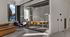 Stylish and modern conference room with glass walls, vibrant orange chairs around a sleek table, and purple lounge chairs, perfect for creative meetings and dynamic discussions.