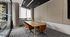 Modern conference room with stylish orange chairs, a large wooden table, and floor-to-ceiling windows offering natural light.