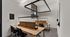 Modern co-working space with sleek wooden desks, ergonomic chairs, and contemporary lighting, perfect for productive study sessions.