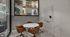 Modern meeting space with sleek round table and stylish chairs, featuring a large window for natural lighting and a chic minimalist design.
