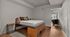 Modern bedroom with a sleek wooden bed, elegant decor, and a glimpse of a stylish workspace. Bright, spacious, and inviting.