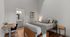 Inviting bedroom with modern decor, featuring a cozy bed, stylish desk, and elegant ensuite bathroom.