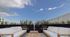 Chic rooftop terrace featuring elegant lounge seating, wooden tables, and lush greenery under a bright blue sky.