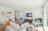 Open living room  and kitchen with large windows and designer finishes.