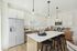 Open living room  and kitchen with large windows and designer finishes.