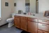 Stylish bathroom featuring wooden cabinetry, modern sink, and chic decor accents.
