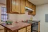 Cozy kitchen with wooden cabinets, modern stove, and decorative elements enhancing warmth.