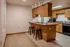 Inviting kitchen with wooden cabinetry, bar seating, and modern appliances.