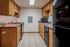 Inviting kitchen with wooden cabinetry, modern appliances, and tiled flooring.