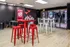 Chic community lounge with red and white themed decor, featuring high tables and stools.