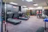 Modern fitness center featuring treadmills, elliptical machines, and a variety of free weights.