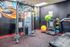 Modern fitness room featuring colorful gym equipment, sleek machines, and motivational art on the walls.