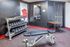 Contemporary gym with dumbbells and an adjustable bench in a sleek, black-accented space.