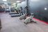 Modern gym facility with state-of-the-art exercise bikes and treadmills, complemented by colorful wall art.